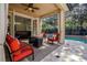 Covered patio with tiled flooring, comfortable seating, and views of the pool and beautifully landscaped backyard at 14003 Hampshire Bay Cir, Winter Garden, FL 34787