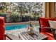 Outdoor screened pool is equipped with wine glasses and cooler, with outdoor seating, and lush landscaping at 14003 Hampshire Bay Cir, Winter Garden, FL 34787