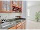 Inviting wet bar with granite countertops, wine storage, and glass cabinets at 14003 Hampshire Bay Cir, Winter Garden, FL 34787