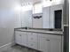 Modern bathroom featuring double sinks, a large walk-in shower, and neutral tile at 14906 Speer Lake Dr, Winter Garden, FL 34787