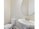 Powder room featuring white fixtures, a pedestal sink and a round mirror at 14906 Speer Lake Dr, Winter Garden, FL 34787