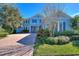 Beautifully landscaped front yard with brick paver driveway leading to a charming two-story home at 14906 Speer Lake Dr, Winter Garden, FL 34787