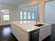 Kitchen island with a sink, dishwasher, and white cabinets at 14906 Speer Lake Dr, Winter Garden, FL 34787