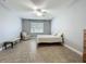 Bedroom with light walls, a ceiling fan, window, a bed and seating at 17146 Cypress Preserve Pkwy, Orlando, FL 32820