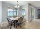 Cozy dining area features a round table, chandelier, and lots of natural light from large windows at 17146 Cypress Preserve Pkwy, Orlando, FL 32820