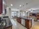 Open kitchen featuring dark wood cabinets, an island with seating, and views into the dining and living areas at 17146 Cypress Preserve Pkwy, Orlando, FL 32820