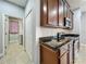 Kitchen area with dark cabinetry, stainless steel appliances, and a view toward the laundry room at 17146 Cypress Preserve Pkwy, Orlando, FL 32820