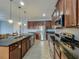 Modern kitchen featuring stainless steel appliances, granite countertops, and ample dark wood cabinetry at 17146 Cypress Preserve Pkwy, Orlando, FL 32820