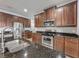 Modern kitchen featuring stainless steel appliances, dark wood cabinets, and granite countertops at 17146 Cypress Preserve Pkwy, Orlando, FL 32820