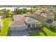 Aerial view of a well-manicured single Gathering home with lush lawn and view of the lake at 1780 Southern Red Oak Ct, Ocoee, FL 34761