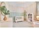 Bright Bedroom with a white crib, sage green trim, and a comfortable chair and shelves for a sweet and welcoming space at 1780 Southern Red Oak Ct, Ocoee, FL 34761