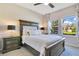 Comfortable bedroom with a decorative headboard, luxurious bedding, bedside tables and lots of natural light at 1780 Southern Red Oak Ct, Ocoee, FL 34761