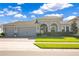 Charming single-story home featuring a three-car garage, an arched entryway, and a well-manicured lawn at 1780 Southern Red Oak Ct, Ocoee, FL 34761