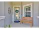 Close up view of the welcoming front porch with bench, plants, and glass front door at 1780 Southern Red Oak Ct, Ocoee, FL 34761