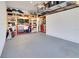 View of a clean, organized garage with shelving, tool storage, and gray epoxy flooring at 1780 Southern Red Oak Ct, Ocoee, FL 34761