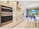 Modern kitchen with stainless steel appliances, custom cabinets, and access to the dining area at 1780 Southern Red Oak Ct, Ocoee, FL 34761