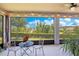 Scenic view from the screened lanai with outdoor seating, overlooking a serene lake and lush landscaping at 1780 Southern Red Oak Ct, Ocoee, FL 34761