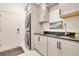 Well-organized laundry room with modern stacked washer and dryer, sleek countertop, and ample cabinet storage at 1780 Southern Red Oak Ct, Ocoee, FL 34761
