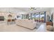Bright open-concept living room connected to kitchen, featuring tile floors and large windows at 1780 Southern Red Oak Ct, Ocoee, FL 34761