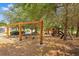 View of a playground with swings and a playhouse in a park-like setting with trees at 1780 Southern Red Oak Ct, Ocoee, FL 34761