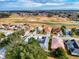 Community aerial view showcasing homes near a golf course with beautiful green landscapes at 17816 Se 115Th Ct, Summerfield, FL 34491