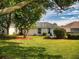 Spacious backyard with green grass and mature trees provides a serene and private outdoor space at 17816 Se 115Th Ct, Summerfield, FL 34491