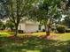Lush backyard features mature trees and manicured lawn, offering serene outdoor living at 17816 Se 115Th Ct, Summerfield, FL 34491