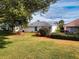 Spacious backyard featuring lush green grass and manicured landscaping with mulch beds at 17816 Se 115Th Ct, Summerfield, FL 34491