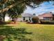 Well maintained backyard with healthy green grass, trimmed bushes and trees, with mulch surrounding bushes at 17816 Se 115Th Ct, Summerfield, FL 34491