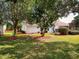 Lush backyard with trees and mulch beds surrounding green lawn, a serene outdoor space at 17816 Se 115Th Ct, Summerfield, FL 34491