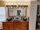 Bathroom featuring a double sink vanity, granite countertop, and modern fixtures at 17816 Se 115Th Ct, Summerfield, FL 34491