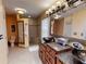 Bathroom featuring dual vanities, tiled shower, and a decorative light fixture at 17816 Se 115Th Ct, Summerfield, FL 34491