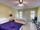 Bedroom featuring two twin beds, ceiling fan, and an exterior door at 17816 Se 115Th Ct, Summerfield, FL 34491