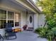 Welcoming covered front porch with ample seating, plants, and classic front door at 17816 Se 115Th Ct, Summerfield, FL 34491