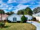 Charming home with well-manicured front yard, lush landscaping, and a paved driveway at 17816 Se 115Th Ct, Summerfield, FL 34491