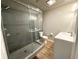 Modern bathroom featuring glass shower, white vanity, and wood look tile flooring at 1809 Pineview Cir, Winter Park, FL 32792