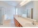 Bright bathroom features a double sink vanity, soaking tub, and glass enclosed shower at 19756 Glen Elm Way, Orlando, FL 32833