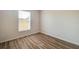 Cozy bedroom featuring neutral paint, wood-look floors, and ample natural light from the window at 19756 Glen Elm Way, Orlando, FL 32833