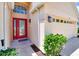 Home exterior featuring a bright red front door, arched window and attached two-car garage at 19756 Glen Elm Way, Orlando, FL 32833
