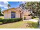 Single-story home with a well-manicured lawn, arched window, and attached two-car garage at 19756 Glen Elm Way, Orlando, FL 32833