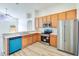 Well-lit kitchen featuring stainless steel appliances, wooden cabinets, and a breakfast bar open to the living area at 19756 Glen Elm Way, Orlando, FL 32833