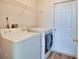 Functional laundry room with washer, dryer, and overhead storage shelf for convenience at 19756 Glen Elm Way, Orlando, FL 32833