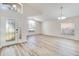 Open-concept living room with vaulted ceilings, large windows, and stylish wood-look flooring at 19756 Glen Elm Way, Orlando, FL 32833