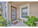 Inviting entryway featuring a wood front door, wreath, potted plants and a welcome mat at 212 Belvedere Way, Sanford, FL 32773