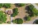 Aerial view of a light brown roofed house, mature trees, a road and green grass at 21343 Reindeer Rd, Christmas, FL 32709