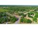 Aerial view of a residential property with surrounding lush greenery and a winding road nearby at 21343 Reindeer Rd, Christmas, FL 32709