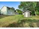 Large backyard with a storage shed, lush lawn, and mature trees providing ample shade at 21343 Reindeer Rd, Christmas, FL 32709