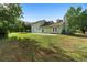 Well-maintained backyard featuring a concrete patio, lush grass, and mature trees at 21343 Reindeer Rd, Christmas, FL 32709
