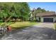 A one-story home with a long driveway, a spacious yard, and lush greenery at 21343 Reindeer Rd, Christmas, FL 32709