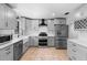 This renovated kitchen features new stainless steel appliances and light grey cabinets with white countertops at 21343 Reindeer Rd, Christmas, FL 32709
